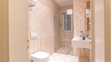 Une salle de bain avec des toilettes, un lavabo et une douche.