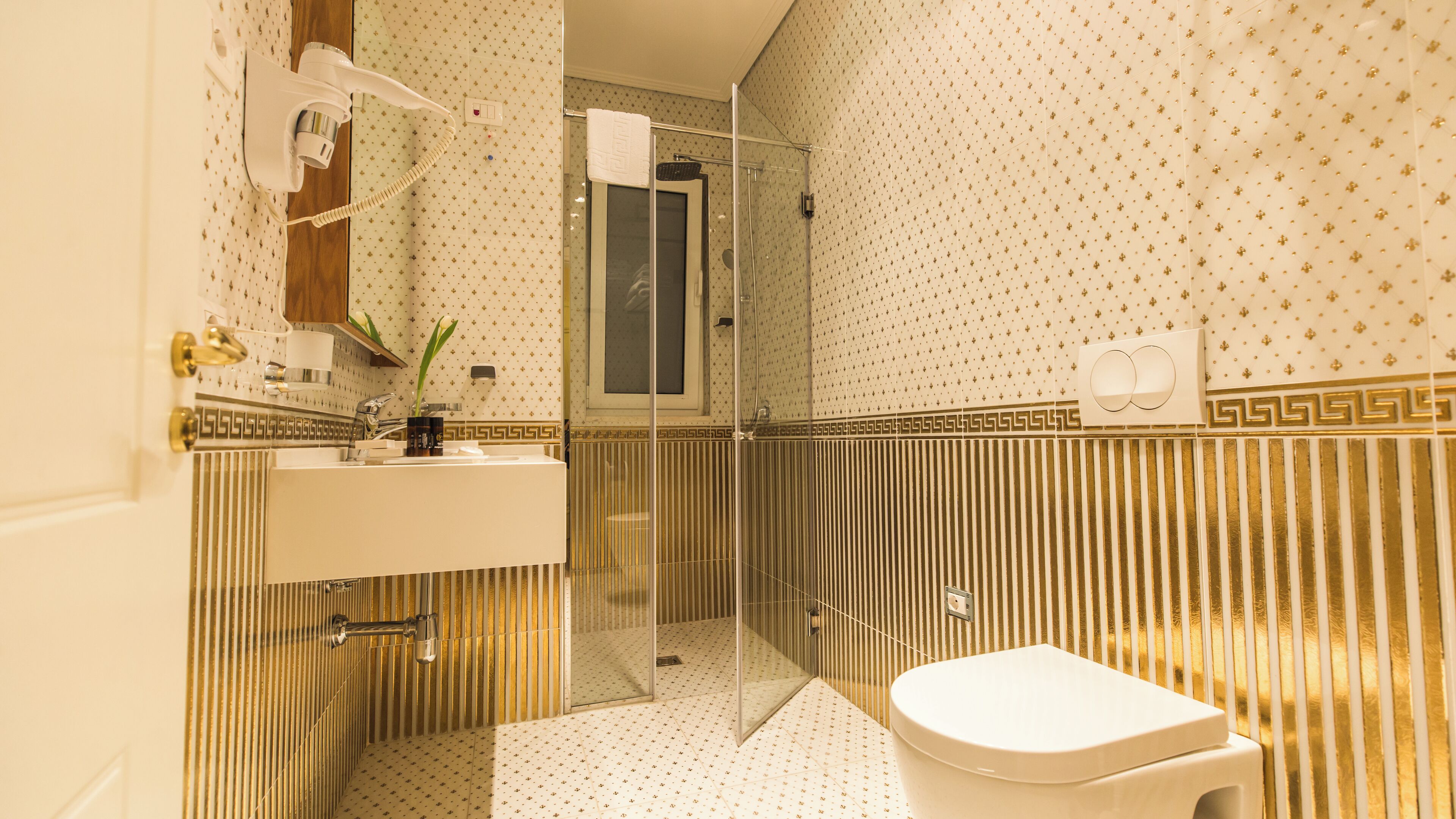 A bathroom with a shower, toilet, sink, and a mirror.