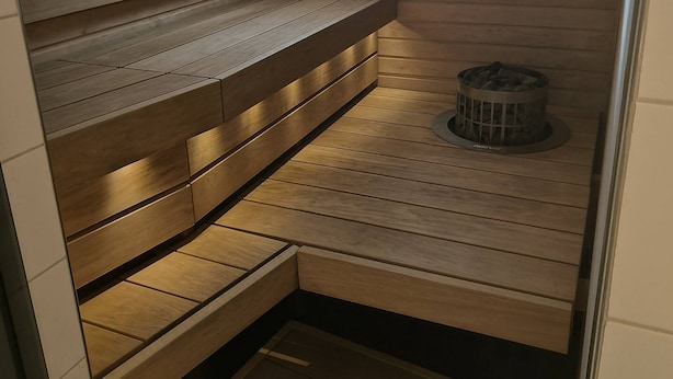 Un sauna avec des bancs en bois et une petite fenêtre.