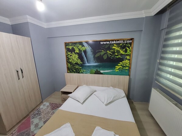 A bedroom with a bed, a wardrobe, a nightstand, and a large poster of a waterfall. - çorlu suit (Çorlu)