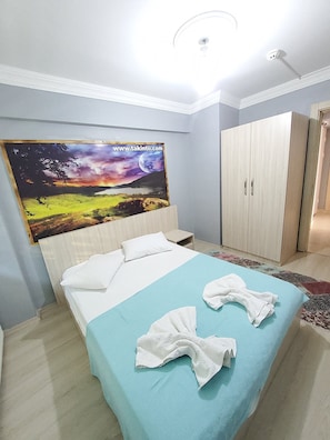 Un dormitorio con cama, armario y un cuadro en la pared.