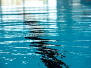Primer plano de una piscina con agua cristalina y ondulaciones visibles.