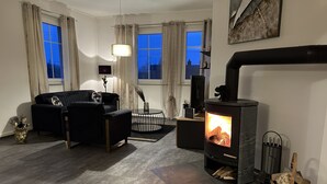 Una sala de estar moderna con chimenea, un sofá, una mesa de centro y una lámpara.