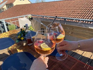A rooftop terrace with a table set for two, featuring a bottle, glasses, and a potted plant. - 100 sqm cozy apartment with fireplace – quiet and modern – Stay TNT (Geislingen)