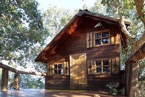 A wooden cabin with a sloped roof, large windows, and a wooden deck. - Villa CYN-pool, billiards, piano and miniature golf (Santo Stefano di Camastra)