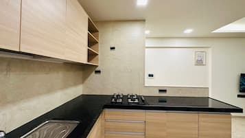 Refrigerador, placa de cocina, utensilios de cocina, mesa de comedor