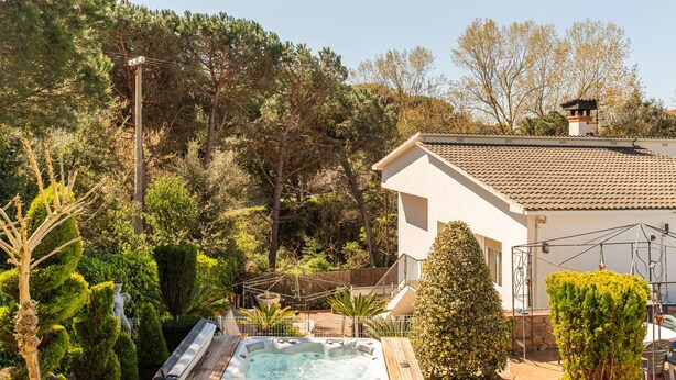 Un quartier résidentiel doté d’un jacuzzi, d’une terrasse en bois et d’une maison avec un toit en tuiles.