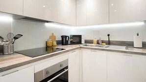 Una cocina moderna con estufa integrada, microondas y pileta.