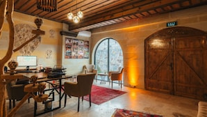 A rustic room with a wooden ceiling, a large arched window, a desk with a computer, and a wooden door marked 'EXIT'. - Dream of Stones Cappadocia (Nevşehir)
