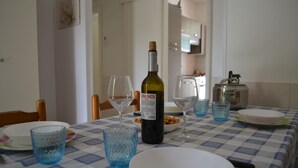 A dining table set with a bottle of wine, glasses, plates, and bowls. - Casa Amanda in Torre Dell'orso (Melendugno)
