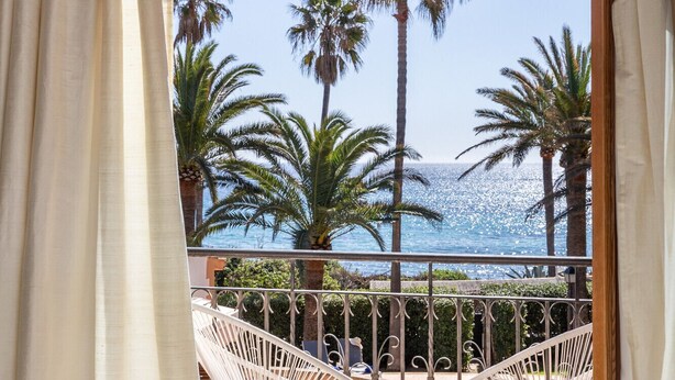 A balcony with a view of palm trees and the sea. - Brisa (Son Servera)