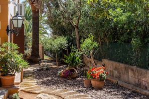 A garden pathway with potted plants and a stone wall. - Brisa (Son Servera)