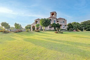 A large, modern house with a spacious lawn and multiple entry points. - Alaya Stays Casa Avakasha 4 BHK Villa  (Gurugram)