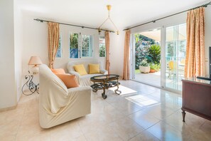 A spacious living room with a sofa, a coffee table, and a television. - Ferrer , villa near the beach (Alcúdia)