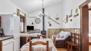 Una cocina con una mesa de comedor, sillas, un refrigerador, un lavaplatos y una estufa.