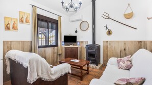 Una sala de estar con chimenea, televisión y una mesa de comedor.