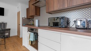 Une cuisine moderne avec des meubles en bois, un four à micro-ondes, un grille-pain et un four encastré.