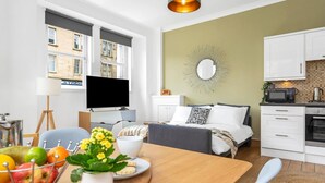 Un appartement moderne comprenant un coin repas, une cuisine et une chambre.