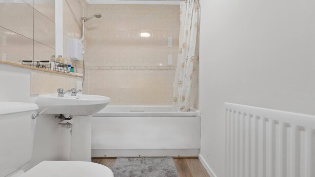 Een badkamer met toilet, wastafel en bad.