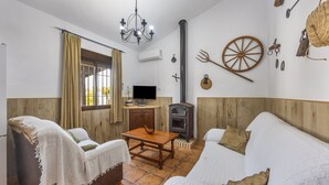 Een gezellige woonkamer met een open haard, houten meubels en een rustieke inrichting.