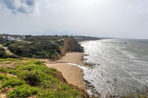 A coastal landscape with a sandy beach, rocky cliffs, and a view of the ocean. - Holiday Home 'La Raya' with Private Pool, Wi-Fi and Air Conditioning (Conil de la Fontera)