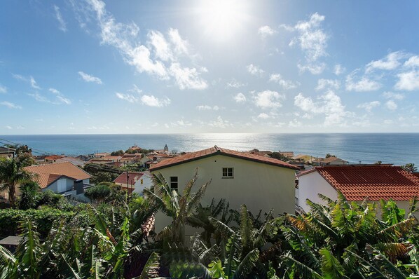 Une ville côtière avec des bâtiments, un ciel dégagé et la mer en arrière-plan.