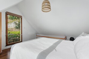 A bedroom with a bed, a window, and a ceiling light fixture. - Romantic Ocean Getaway (Jardim do Mar)