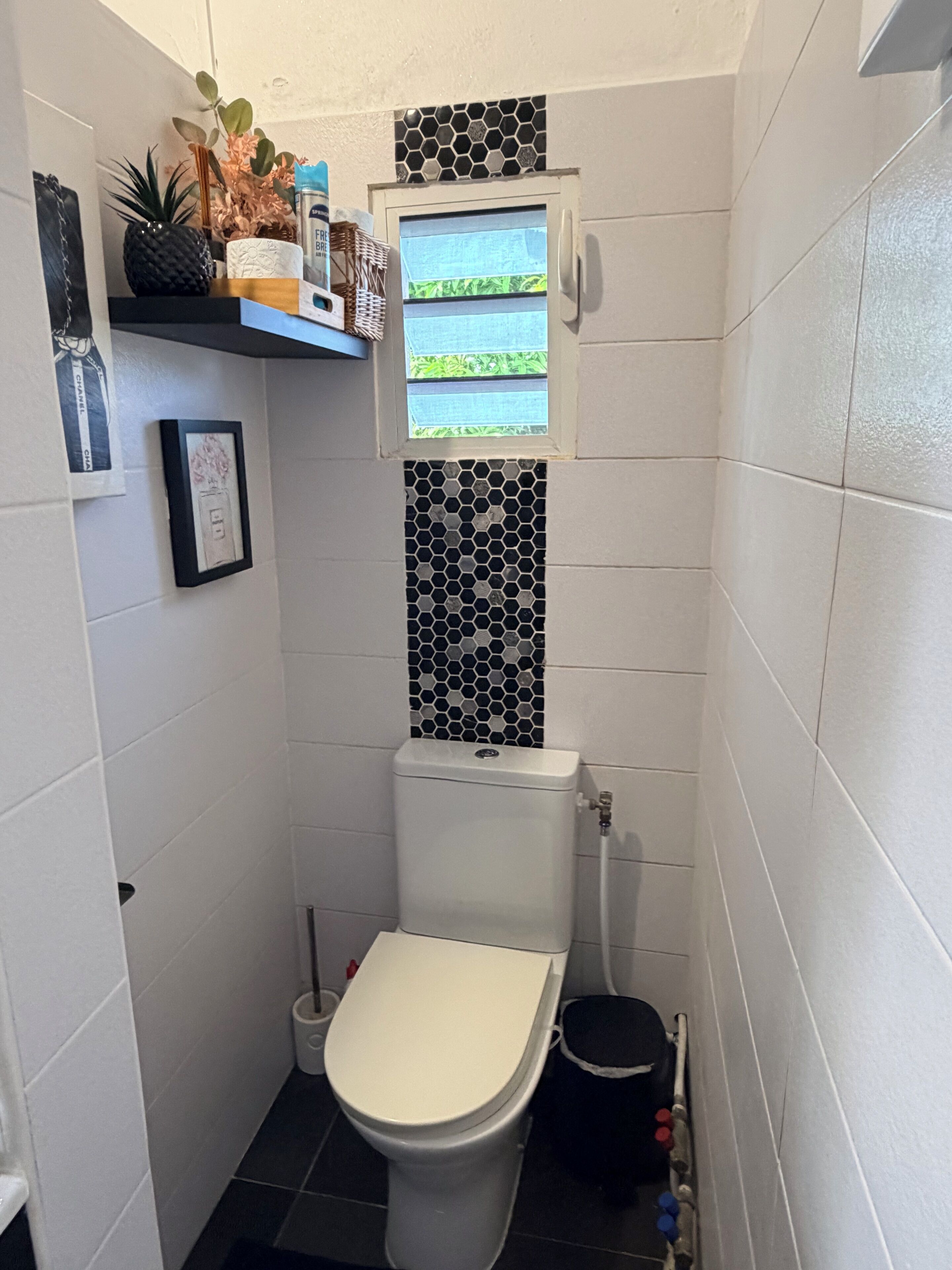 Un baño pequeño y funcional con inodoro, bidé y ventana sobre el inodoro.