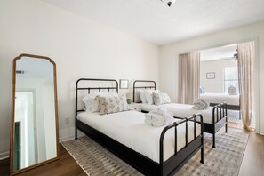 Ein Hotelzimmer mit zwei Betten, einem großen Spiegel und Blick ins Freie.