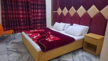 A bed with a red and white bedspread, a headboard with diamond patterns, and a nightstand.