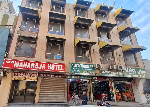A building with multiple businesses including a hotel, an auto trader, and a furniture store. - New Maharaja Hotel (Rawalpindi)