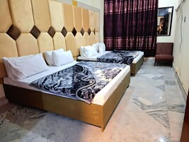 Ein Hotelzimmer mit zwei Betten, einem großen Spiegel und einem Sessel.