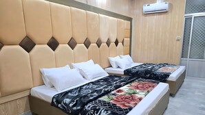 Une chambre d’hôtel avec deux lits, chacun doté d’une tête de lit et de linge de lit blanc.