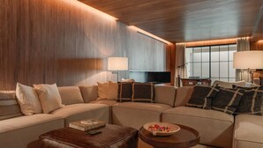 Una sala de estar moderna con un sofá modular, una mesa de centro y un televisor de pantalla plana.