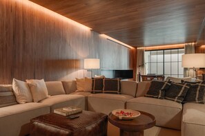 A modern living room with a sectional sofa, a coffee table, and a flat-screen TV. - Villa Mangoni - Brand New Luxury Villa (Funchal)
