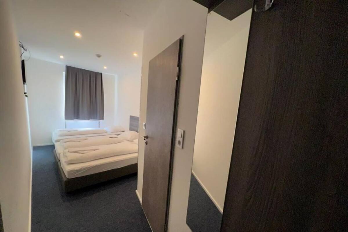 Een hotelkamer met een bed, een kledingkast en een raam met gordijnen.