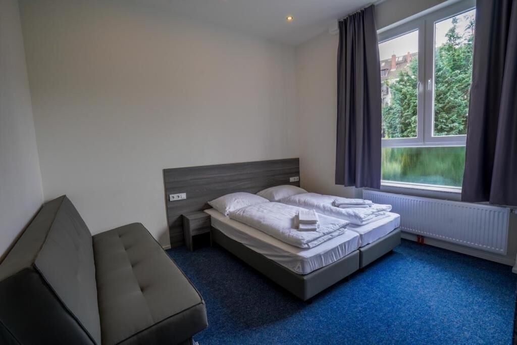 Ein Hotelzimmer mit Bett, Nachttisch, Stuhl und einem Vorhangfenster.