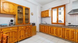 A kitchen with wooden cabinets, a microwave, a coffee maker, and a gas stove.
