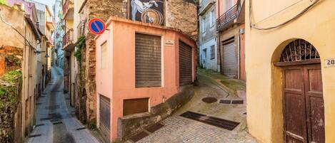 A narrow street with buildings on either side, a no parking sign, and a door with the number 20.