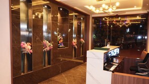 A reception area with a marble reception desk, a computer, and a seating area. - Vishram Executive Rooms (Vasai)