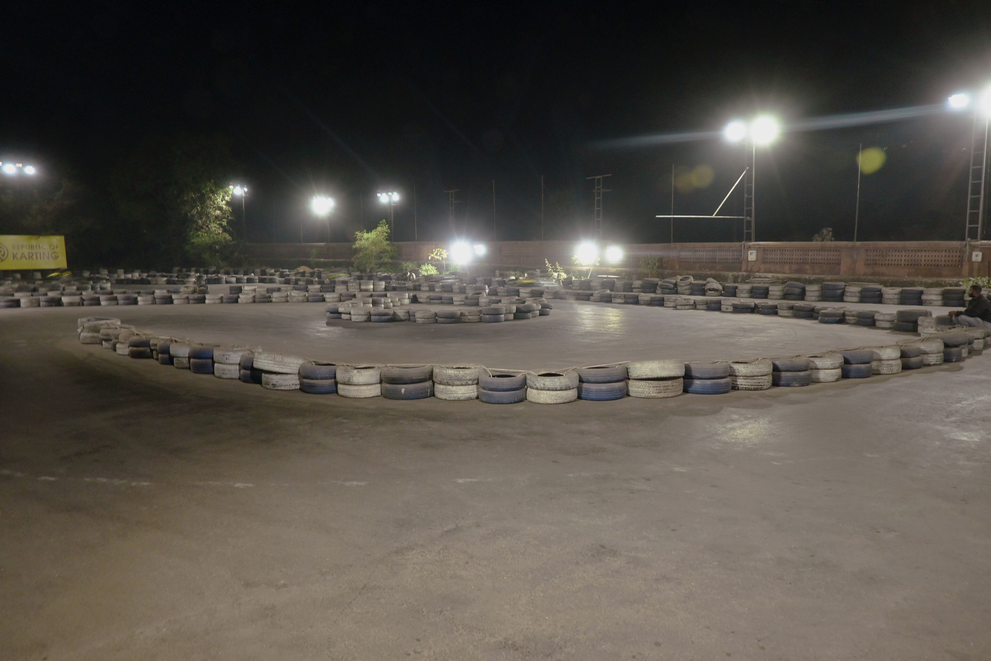 A racetrack with tire barriers and bright lights.