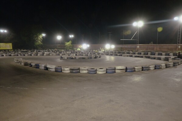 Una pista de carreras con barreras de neumáticos y luces brillantes.