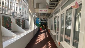Ein Korridor mit einem Schild, auf dem 'ANRI' steht, und einem Fenster mit einer Schmetterlingsdekoration.