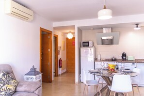 A modern kitchen with a microwave, refrigerator, and dining area with chairs and a table. - Modern, centrally located, with private parking and an elevator   (Altea)