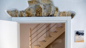 Un mur de pierres sur lequel est accroché un tableau représentant un escalier.