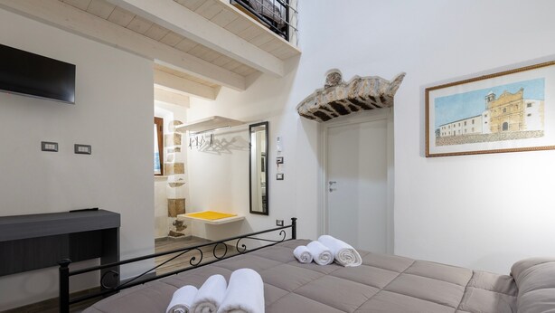 Une chambre d’hôtel avec un lit, une salle de bain avec un lavabo et un tableau au mur.
