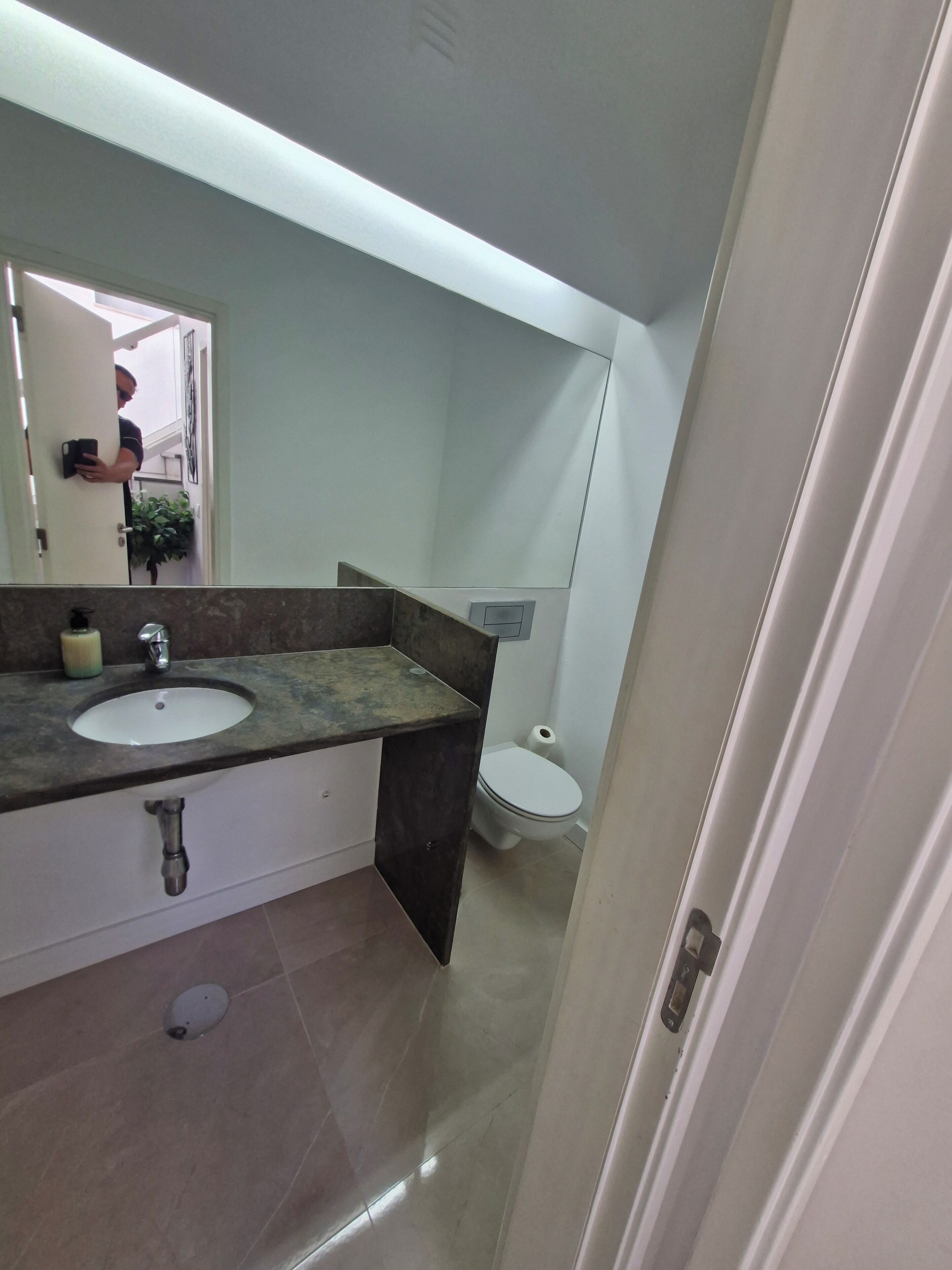 Une salle de bain avec un double lavabo, des toilettes et un miroir.