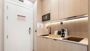 A compact kitchen with a microwave, coffee maker, and a sink. - Dobo Madrid Ricardos (Madrid)