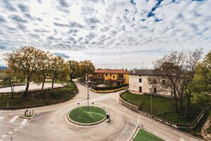 Ein Kreisverkehr mit einer begrünten Mittelinsel, umgeben von Wohngebäuden mit roten Ziegeldächern.