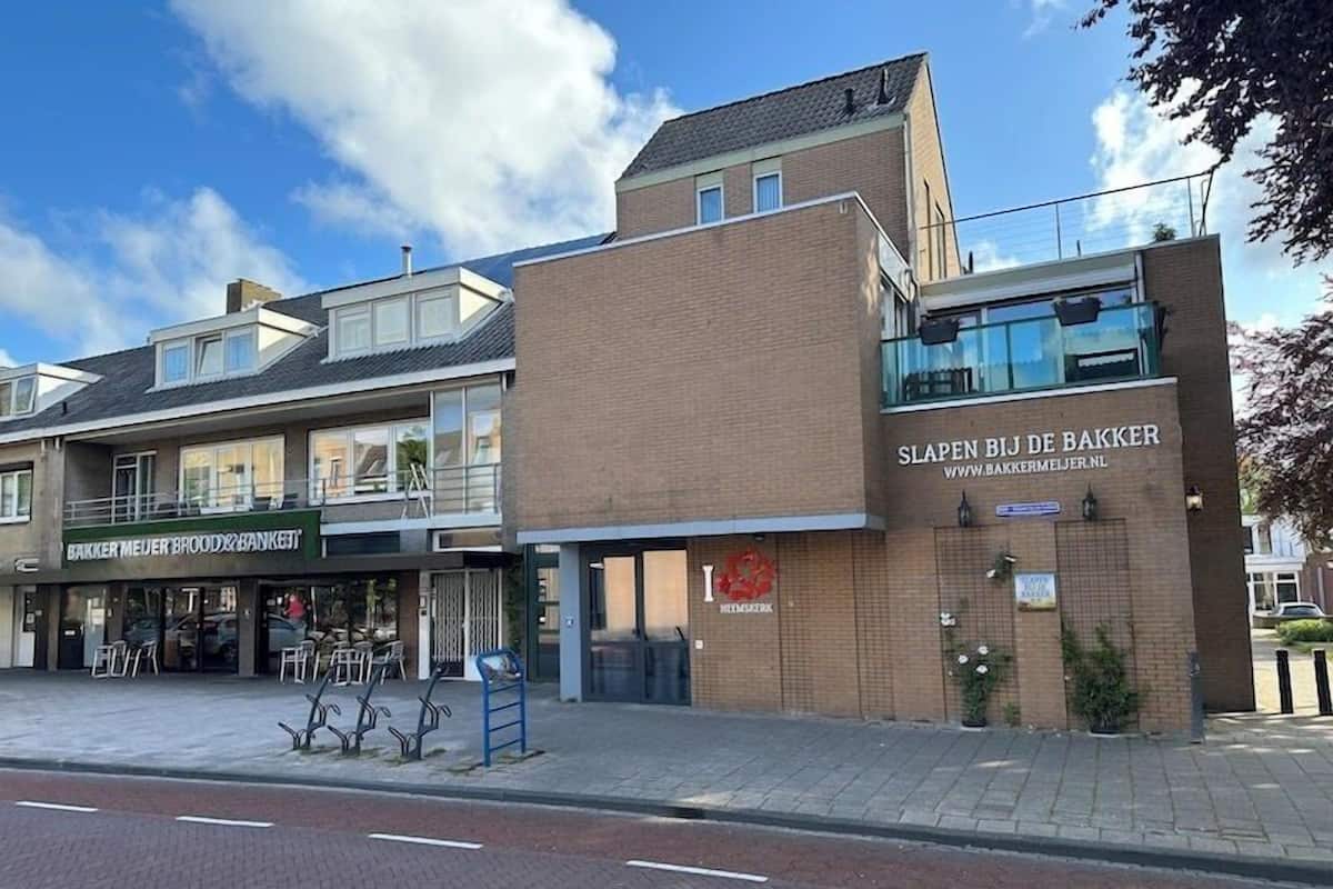 Un edificio con un letrero que dice 'Slapen Bij de Bakker' y otro que dice 'Bakker Meijer Brood & Banket'.